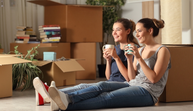 Two girls sitting by boxes