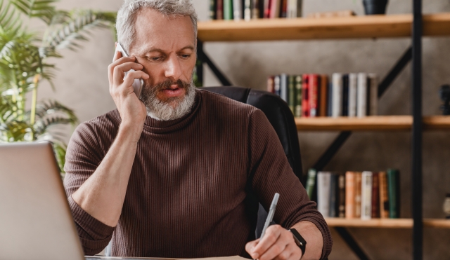 Man with phone taking notes