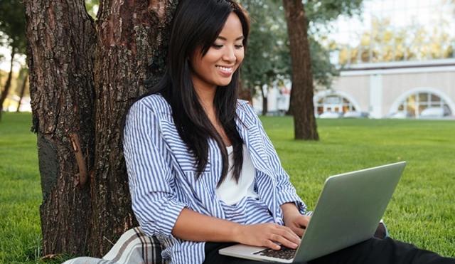 Woman outside looking at computer