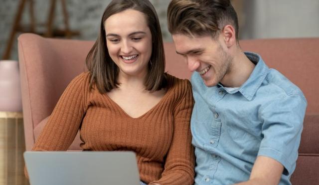 Young couple looking at their laptop.