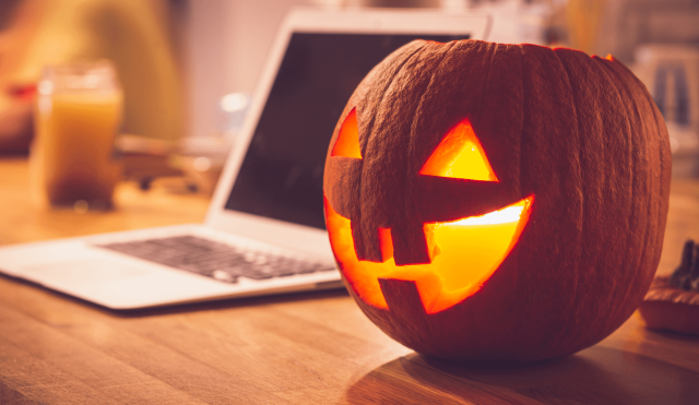Jack-o-lantern next to a laptop