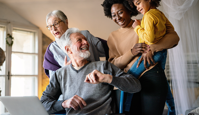 Multi-generational family looks at laptop together