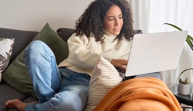 Post college graduate managing finances on a couch
