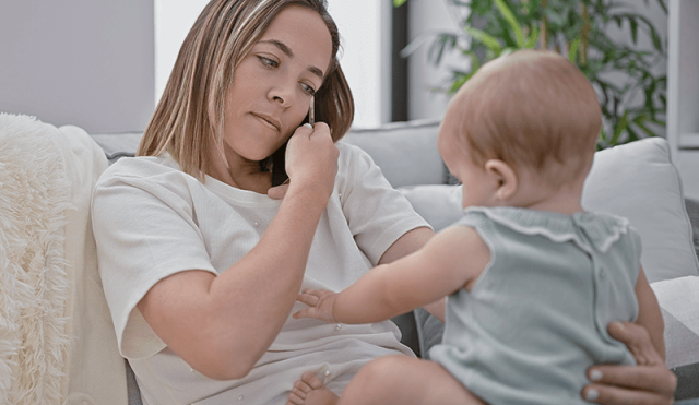 Mother on phone with baby on lap