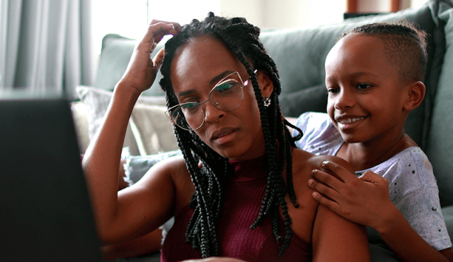 Woman looking at laptop with child