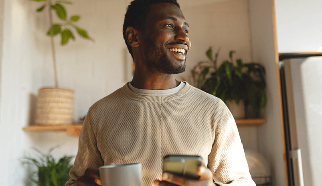 man with coffee and phone in hand