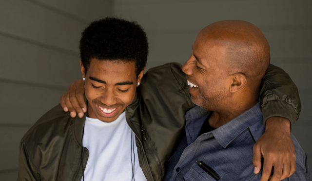 A dad puts his arm around his son