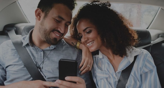 Couple in car with phone