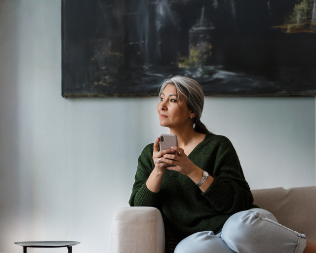 Woman with phone looking out the window