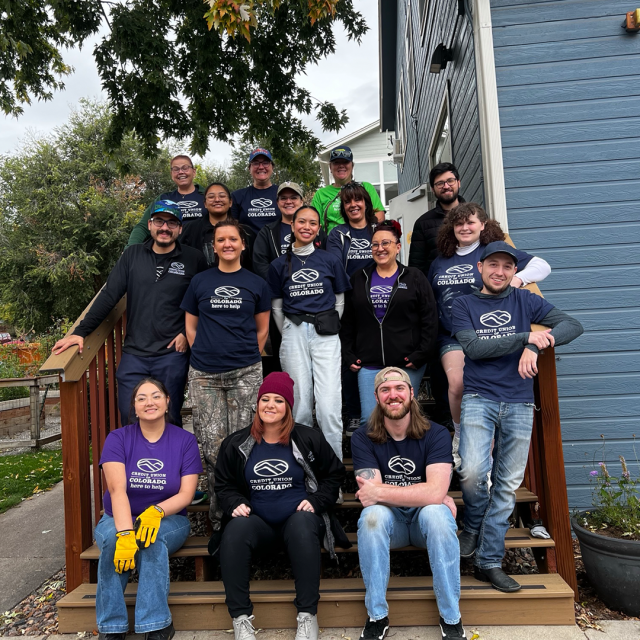 CUofCO employees on steps in front of a home