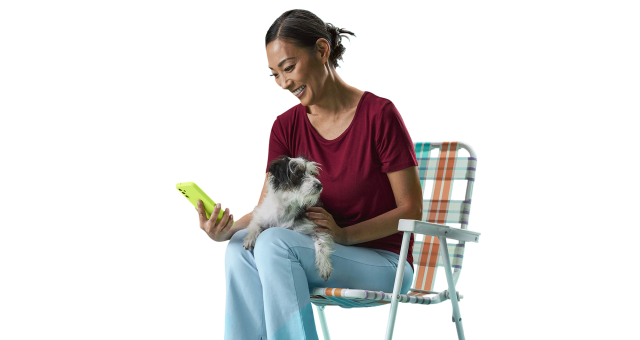 Woman with a dog sitting looking at a phone