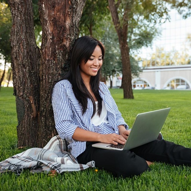 Woman outside looking at computer