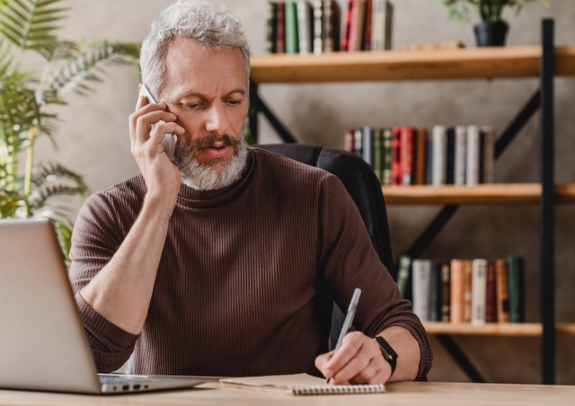 Man with phone taking notes