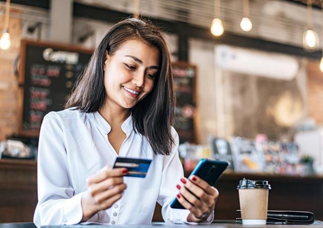 Looking at phone with credit card