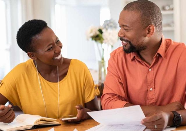 Couple going over finances together at table.