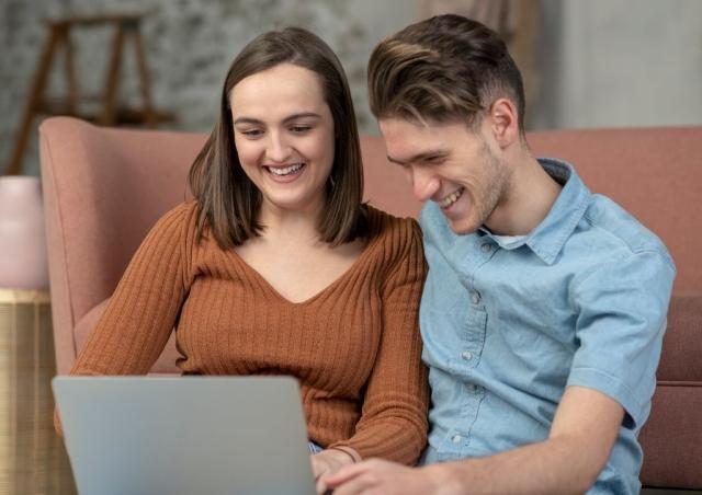 Young couple looking at their laptop.