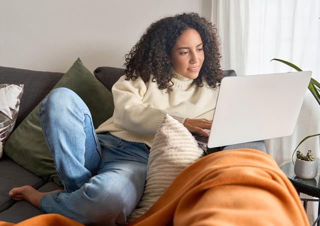 Post college graduate managing finances on a couch