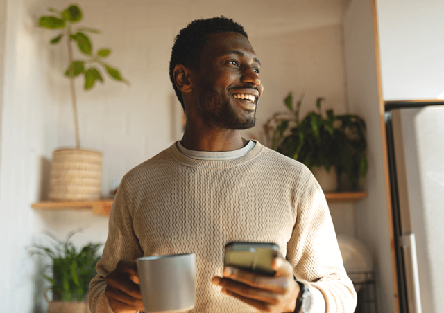 man with coffee and phone in hand